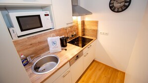 A compact kitchen with a microwave, sink, and wooden countertop. - Deluxe Studio Kaprun TOP 23 (Kaprun)