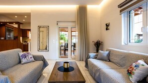 Una sala de estar moderna con dos sofás, una mesa de centro y un espejo grande.