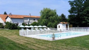 A swimming pool with a white fence, surrounded by a grassy area and a small white building. - 1 Bedroom Private vacation home in Ronsenac (Ronsenac)