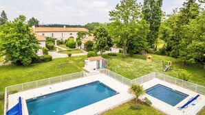 A residential property with a swimming pool, a small play area, and a well-maintained garden.
