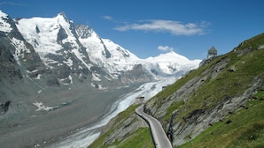 Una carretera de montaña con un glaciar y picos nevados.