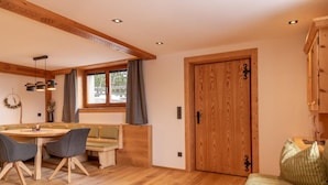 Una habitación acogedora con una mesa de madera, dos sillas, un banco y una puerta de madera.