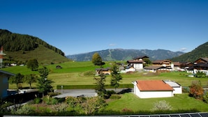 A rural village with traditional houses, a clear sky, and mountains in the background. - Panorama Apartments Bruck TOP 1 (Bruck an der Grossglocknerstrasse)