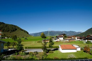 A rural village with traditional houses, a clear sky, and mountains in the background. - Panorama Apartments Bruck TOP 1 (Bruck an der Grossglocknerstrasse)