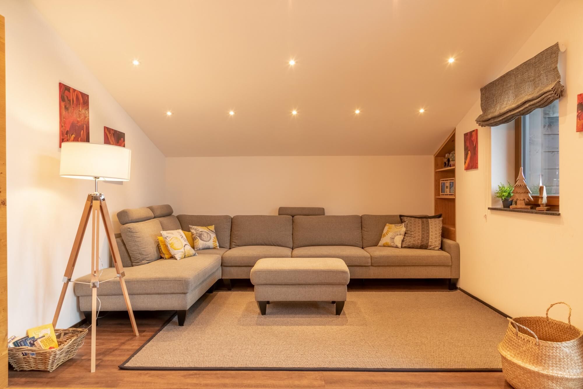 Una sala de estar con un sofá modular, una lámpara de pie, una mesita y un ventanal con vistas.