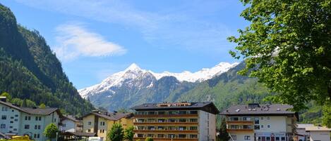A hotel with multiple floors, a restaurant, and a view of snow-capped mountains.