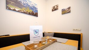 A hotel room with a bed, a table with a tray of candles, and artwork on the walls. - Panorama Apartments Bruck TOP 2 (Bruck an der Grossglocknerstrasse)