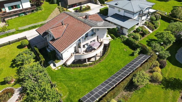 A residential area with modern houses, solar panels, and well-maintained lawns. - Panorama Apartments Bruck TOP 2 (Bruck an der Grossglocknerstrasse)