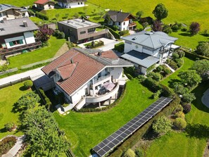 A residential area with modern houses, solar panels, and well-maintained lawns. - Panorama Apartments Bruck TOP 2 (Bruck an der Grossglocknerstrasse)
