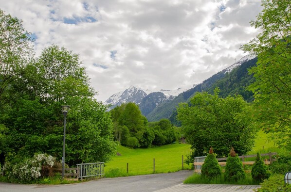 A rural road leading to a mountain with a wooden fence and a lamppost. - Apartment Glacier View 14 2 With Balcony (Kaprun)