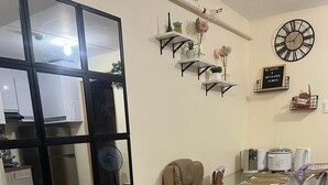 Een woonkamer met een bank, een eettafel en een keukenhoek.