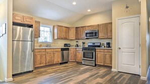 Una cocina moderna con armarios de madera, electrodomésticos de acero inoxidable y una estufa de dos fogones.