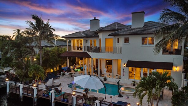 A two-story house with a swimming pool, outdoor seating, and a dock over water. - Luxury Home Villa D' Amore Southern Florida Paradise Sleeps 10 5 Bedroom Villa by RedAwning (Fort Lauderdale)