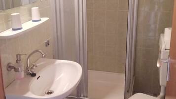 A bathroom with a shower, sink, and toilet.