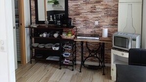 Una cocina con pared de madera, un espejo grande, un microondas y una cafetera.