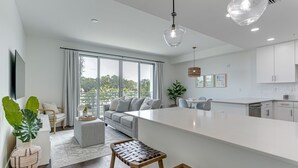 A modern kitchen with white cabinets, a large island, and pendant lighting. - All-New, Waterfront Condo Near Downtown Sarasota (Sarasota)