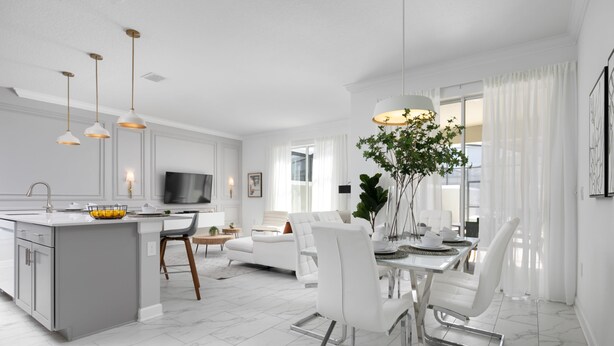 A modern kitchen with a central island, white dining area with chairs, and a large window with curtains.