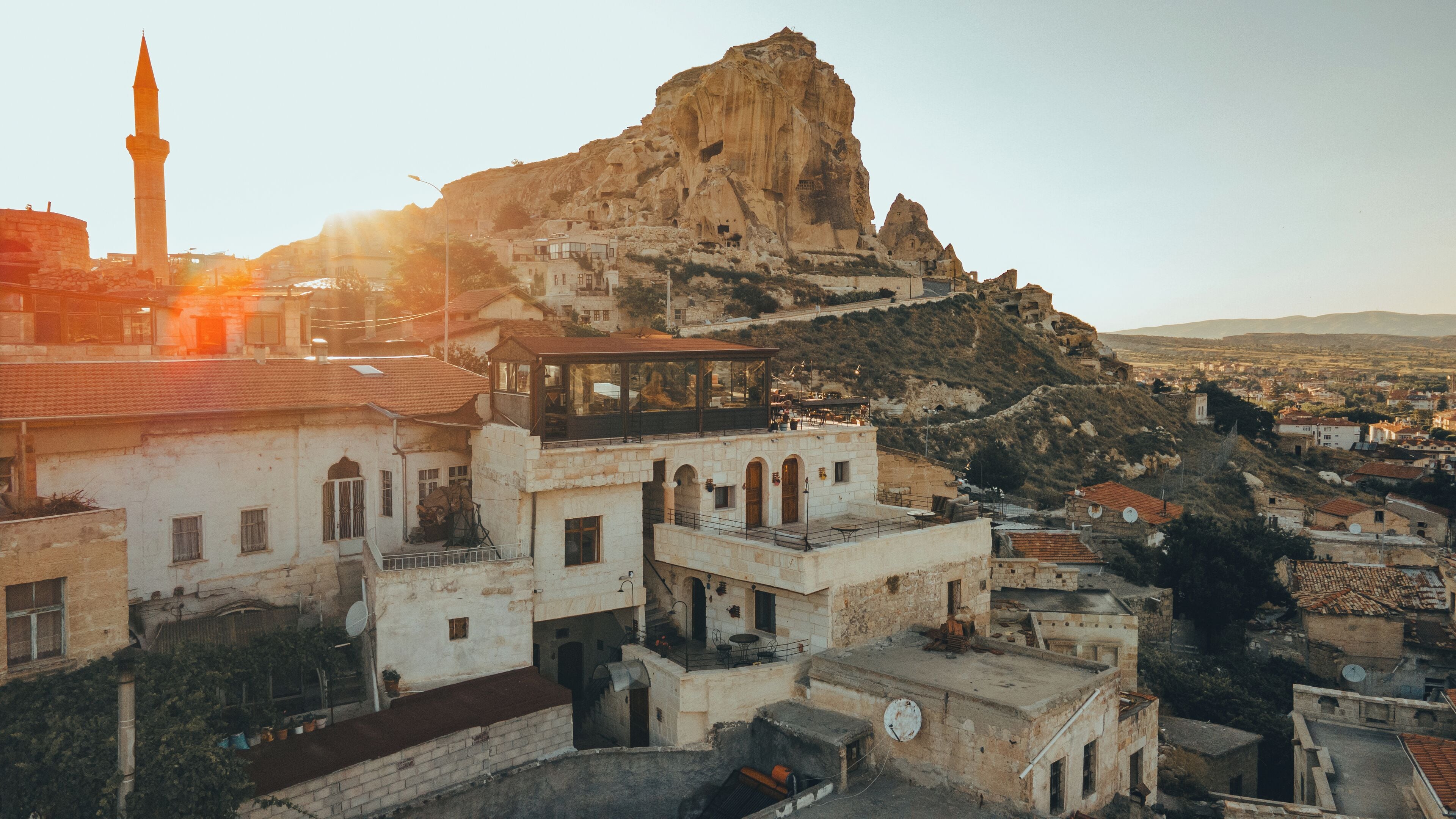 A historic town with a prominent rock formation and a minaret.