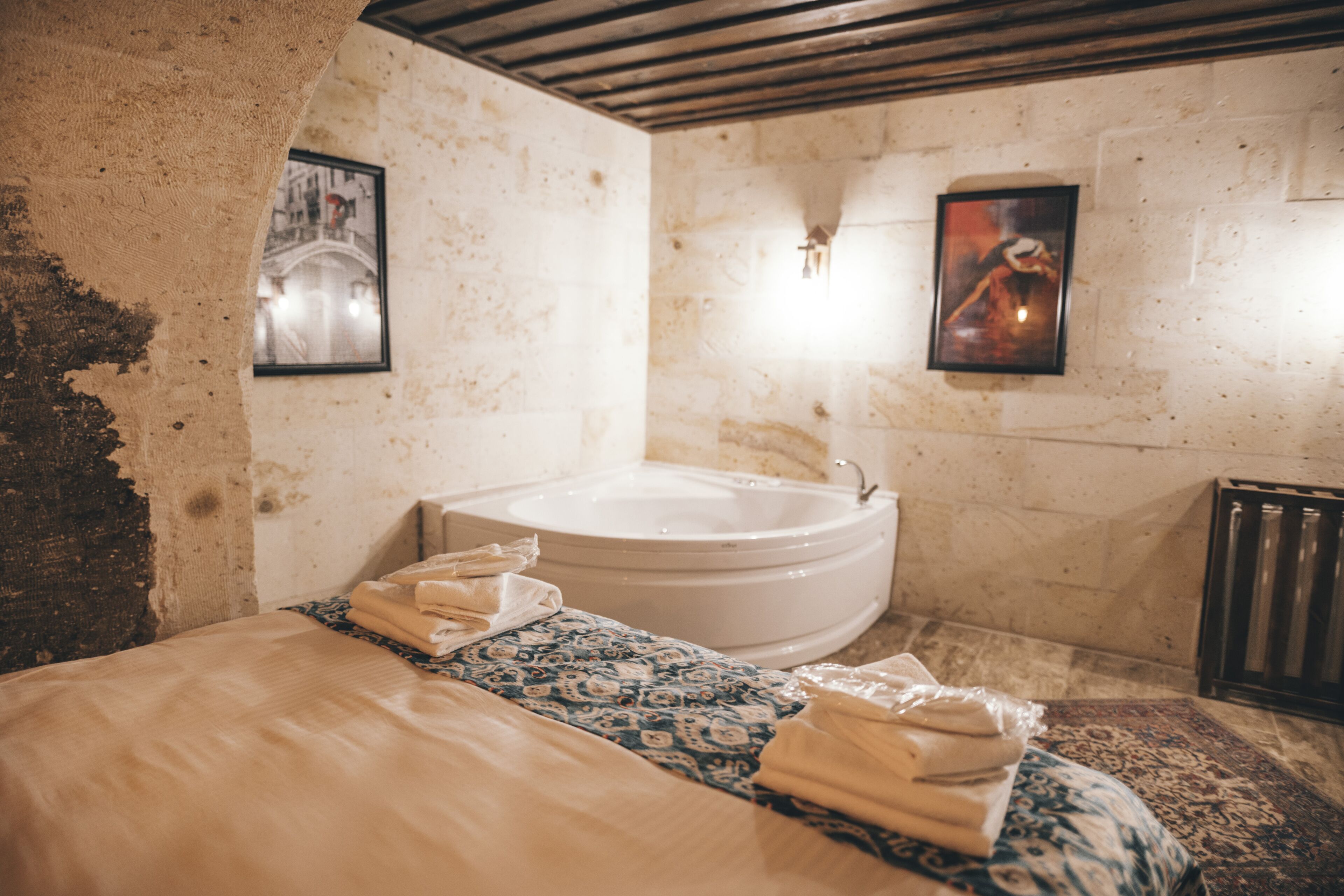 Een kamer met een groot bed, een badkuip en een radiator.