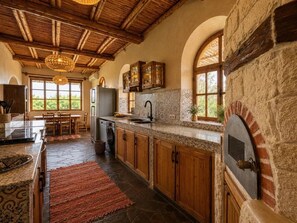A rustic kitchen with stone walls, wooden cabinets, and a built-in oven. - Family Farm House with Animals near Essaouira and Kaouki Beach (Essaouira)