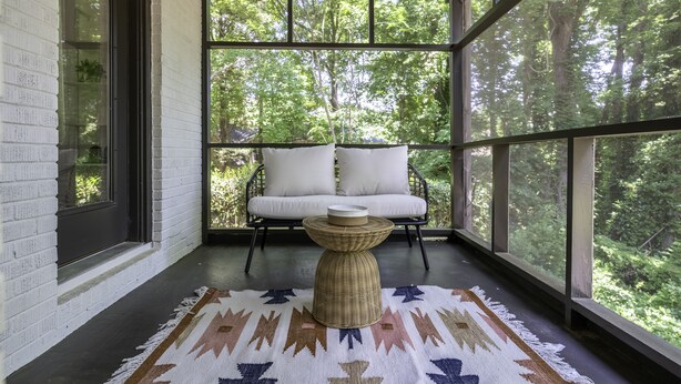 A cozy room with a large window, a wicker table, and a cushioned bench. - 3,700 sqft-Cozy/Private Villa style Ranch in SouthPark-King en Suite-Winter Rdy! (Charlotte)