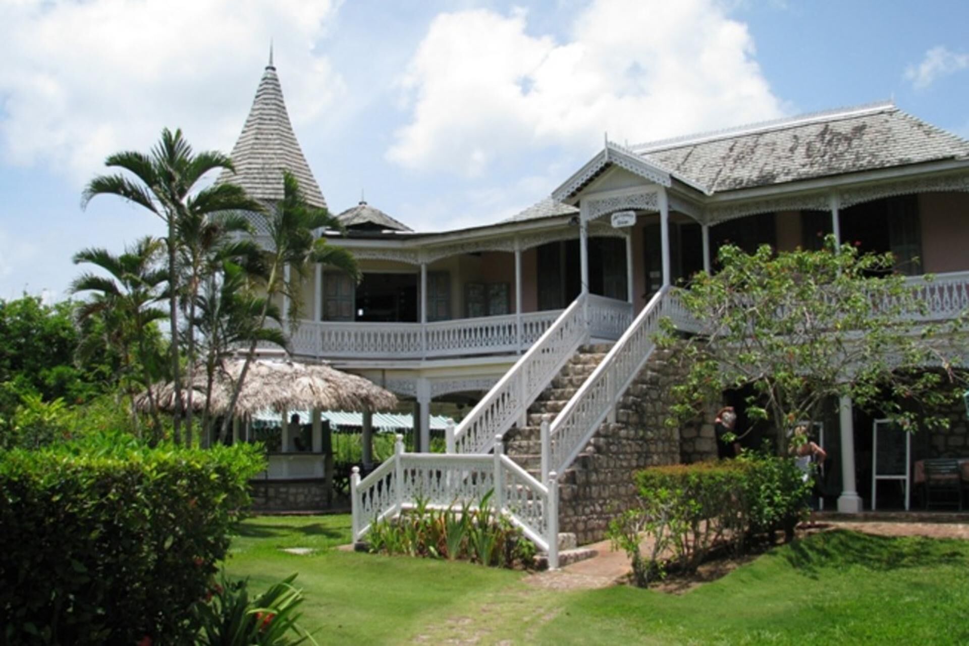 A large, two-story building with a covered porch and a staircase leading to the upper level.