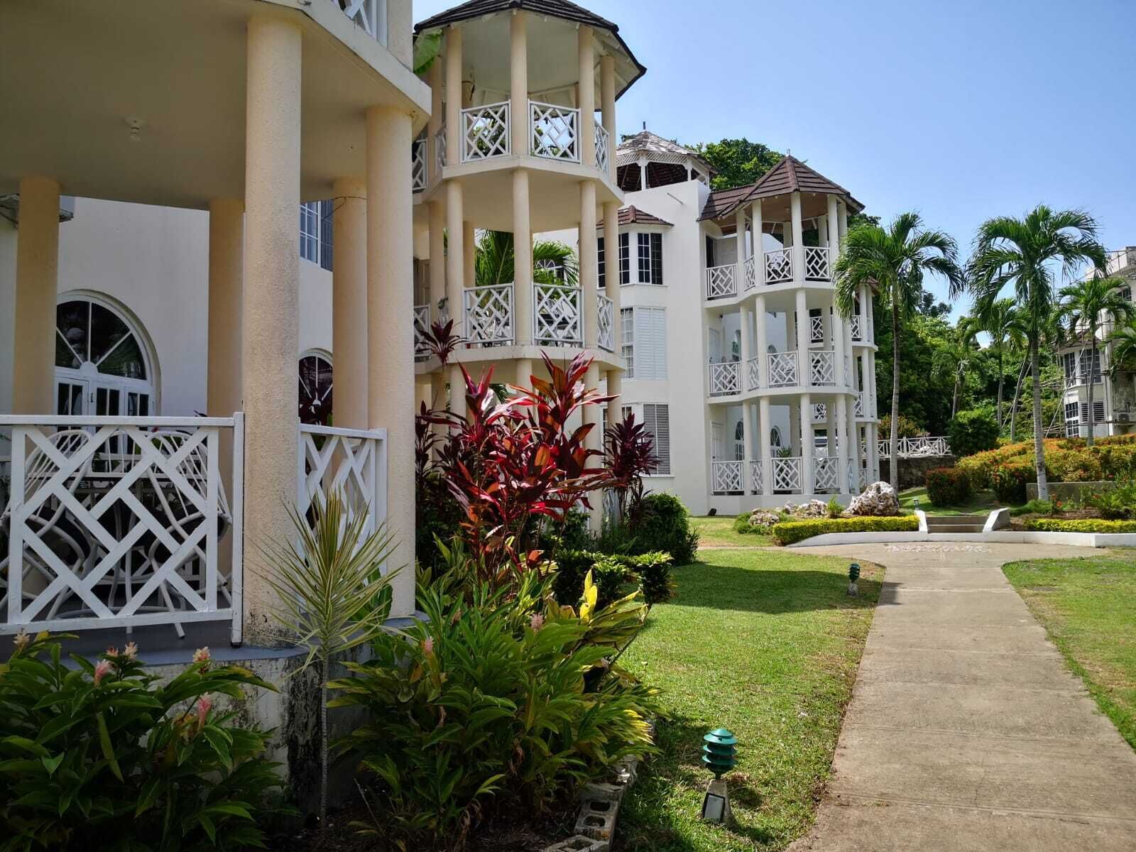 Ein Resort mit mehrstöckigen Gebäuden, Balkonen und üppiger Bepflanzung.