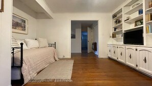 Un dormitorio con una cama, un televisor y una estantería.