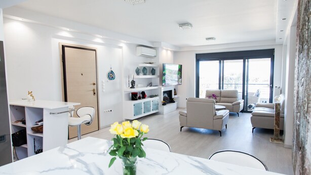 A modern living room with a marble table, a sofa set, and a TV mounted on the wall. - Luxury Apt in the center of Glyfada (Glyfada)