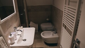 Een kleine badkamer met een wastafel, toilet en handdoekhouder.