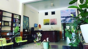A hotel lobby with a reception desk, seating area, and a large window with a view. - Chapi Hotel (Dong Hoi)