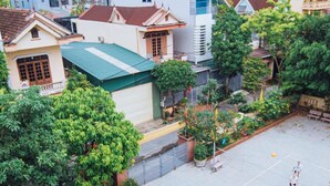 A courtyard with a basketball court, surrounded by residential buildings and greenery. - Chapi Hotel (Dong Hoi)