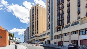 A modern urban street with high-rise buildings, a clear sky, and parked cars. - Ajuda · Belvedere TM Flat With a Magnificent View (Lisboa)
