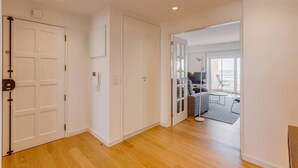 A modern hotel room with a wooden floor, a large window, and a balcony with outdoor seating. - Ajuda · Belvedere TM Flat With a Magnificent View (Lisboa)