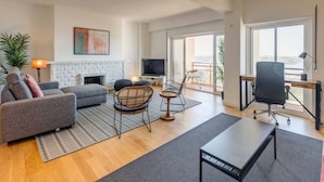 A spacious living room with a fireplace, comfortable seating, a TV, and a balcony with a view. - Ajuda · Belvedere TM Flat With a Magnificent View (Lisboa)