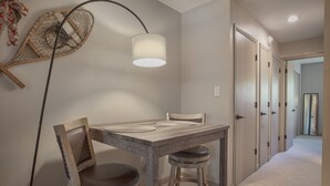 Un comedor con una mesa de madera, dos sillas y una lámpara colgante.