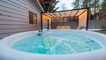 Relax in a hot tub surrounded by a deck and covered patio.