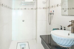 A bathroom with a toilet, a sink, and a shower. - Hezhou Xintai Hotel (Hezhou)