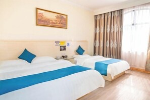 Une chambre d’hôtel avec deux lits, un tableau au mur et une fenêtre avec des rideaux.