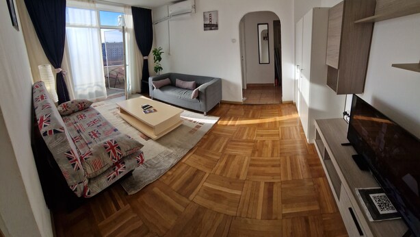 Ein Wohnzimmer mit einer Couch, einem Couchtisch und einem Fernseher.
