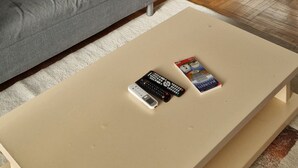 Ein Wohnzimmer mit grauem Sofa, einem beigen Couchtisch und einem gerahmten Bild der Golden Gate Bridge an der Wand.