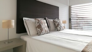 A modern bedroom with a large bed, a dark headboard, and two bedside lamps. - Seaview and private pool - house for 6 (Lourinhã)