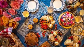 A table set with various pastries, fruits, and a teapot.