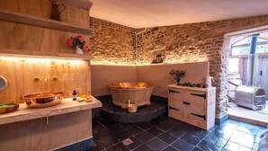 A modern bathroom with a stone wall, a wooden vanity, a freestanding bathtub, and a large window. - Annex Suite: Sleeps 2 (Scunthorpe)