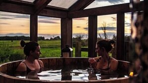 A wooden hot tub with a view of a sunset and a grassy field. - Annex Suite: Sleeps 2 (Scunthorpe)