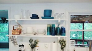 A kitchen with white shelves holding various dishes and glassware. There are plants on the counter and a sign that says "phones only." - Completely renovated lakehouse with all the extras (Warsaw)