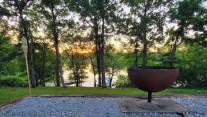 A gravel area with a metal fire pit surrounded by trees. - Completely renovated lakehouse with all the extras (Warsaw)