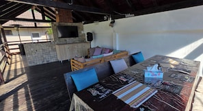 An outdoor patio with a wooden table, chairs, and a cushioned seating area. - Avrigelli, Kids&family Friendly (Avrig)