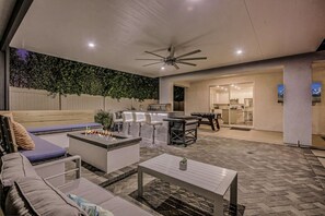 An outdoor patio area with a fire pit, seating, and a bar area.