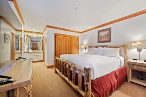Een slaapkamer met een houten bed, een bureau met stoel, een spiegel en een kledingkast.